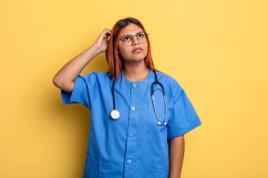 İspanyol kadın şaşkın ve kafası karışık, kaşınıyor. hemşire konsepti