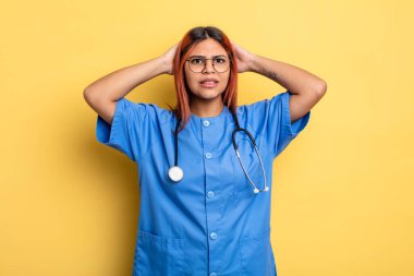 İspanyol kadın kendini stresli, endişeli ya da korkmuş hissediyor, elleri başının üstünde. hemşire konsepti