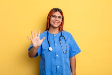 İspanyol kadın gülümsüyor ve arkadaş canlısı görünüyor, beş numarayı gösteriyor. hemşire konsepti