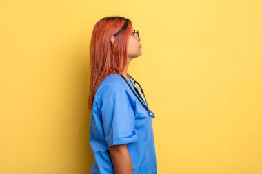 İspanyol kadın profil görüşünde düşünüyor, hayal ediyor ya da hayal kuruyor. hemşire konsepti