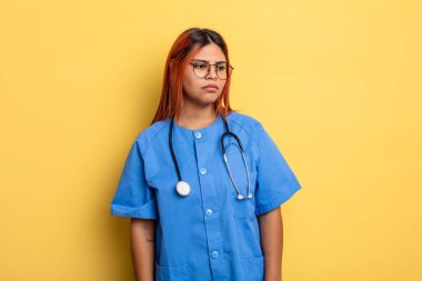 Hispanik kadın üzgün, üzgün ya da kızgın ve yana bakıyor. hemşire konsepti