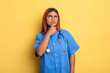 Hispanik kadın düşünüyor, kuşkulu ve şaşkın hissediyor. hemşire konsepti