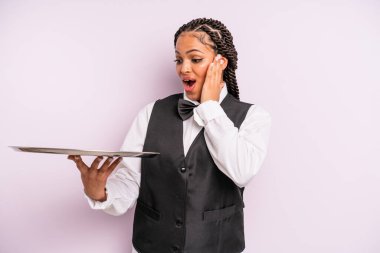 afro black woman feeling happy, excited and surprised. waiter with a tray