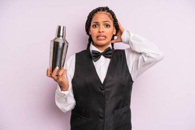 afro black woman feeling stressed, anxious or scared, with hands on head. waiter with a cocktail