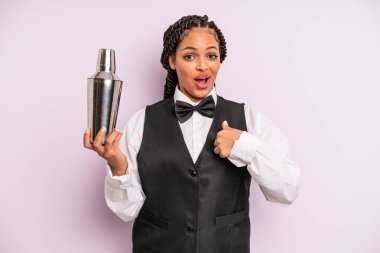 afro black woman feeling happy and pointing to self with an excited. waiter with a cocktail