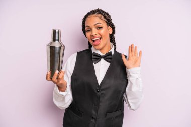 afro black woman smiling happily, waving hand, welcoming and greeting you. waiter with a cocktail