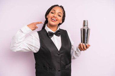 afro black woman smiling confidently pointing to own broad smile. waiter with a cocktail