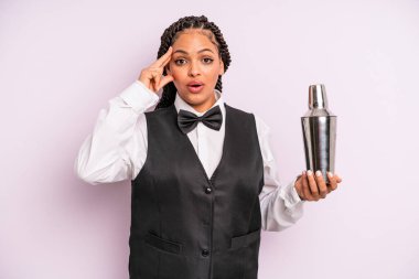 afro black woman looking surprised, realizing a new thought, idea or concept. waiter with a cocktail