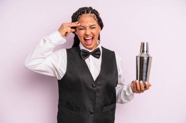 afro black woman looking unhappy and stressed, suicide gesture making gun sign. waiter with a cocktail