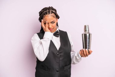 afro black woman feeling bored, frustrated and sleepy after a tiresome. waiter with a cocktail