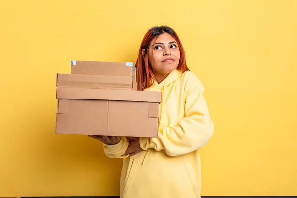 ヒスパニック系の女性は 混乱し 不確定な感じ急いでいる 配送ボックスのコンセプト — ストック写真