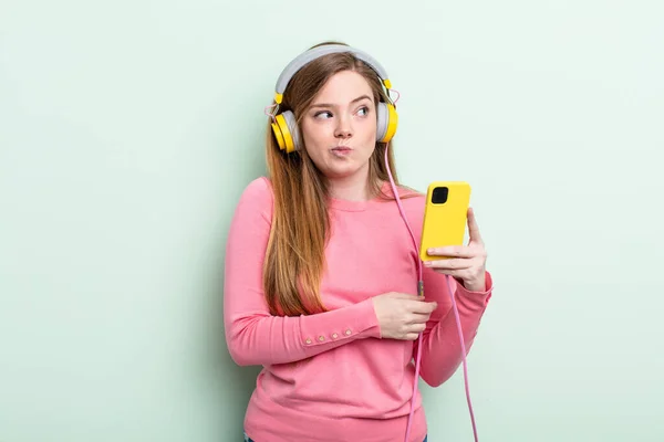 Redhair Woman Shrugging Feeling Confused Uncertain Headphones Smartphone Concept — Stock Photo, Image