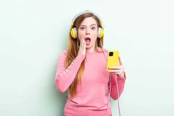 Κοκκινομάλλα Γυναίκα Αισθάνεται Σοκαρισμένη Και Φοβισμένη Ακουστικά Και Έξυπνο Τηλέφωνο — Φωτογραφία Αρχείου
