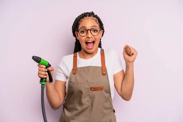 Afro Black Woman Feeling Shocked Laughing Celebrating Success Gardener Hose — Zdjęcie stockowe