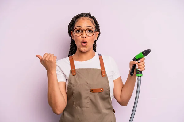 Afro Black Woman Looking Astonished Disbelief Gardener Hose Concept — Zdjęcie stockowe