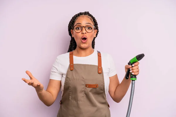 Afro Black Woman Feeling Extremely Shocked Surprised Gardener Hose Concept — Zdjęcie stockowe