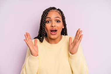 Siyah afro kadın kendini mutlu hissediyor ve inanılmaz bir şeye hayret ediyor.