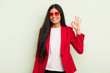 Genç, güzel, İspanyol bir kadın kendini mutlu hissediyor. Onayını iyi bir hareketle gösteriyor. İş kadını kavramı