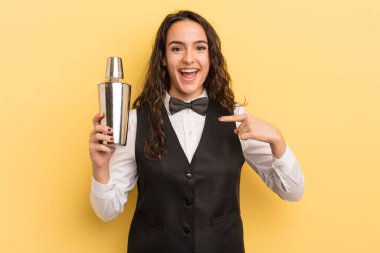 Genç, güzel İspanyol bir kadın kendini mutlu hissediyor ve heyecanla kendini işaret ediyor. barmen ve kokteyl konsepti