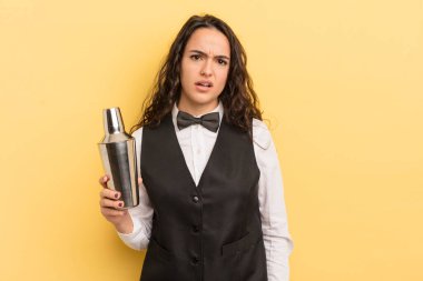 Genç ve güzel İspanyol kadın şaşkın ve şaşkın hissediyor. barmen ve kokteyl konsepti