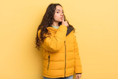 İspanyol güzel kadın sessizlik ve sessizlik istiyor, parmaklarıyla ağzının önünde işaret ediyor, 