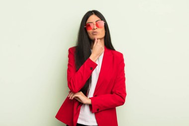 Genç, güzel İspanyol kadın düşünüyor, kuşkulu ve şaşkın hissediyor. İş kadını kavramı