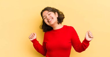 Güzel İspanyol kadın gülümsüyor, kaygısız hissediyor, rahat ve mutlu, dans ediyor ve müzik dinliyor, bir partide eğleniyor.