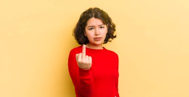 Güzel İspanyol bir kadın kızgın, sinirli, isyankar ve agresif orta parmağını sallayarak karşılık veriyor.