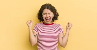 Güzel İspanyol kadın çok mutlu ve şaşırmış görünüyor, başarıyı kutluyor, bağırıyor ve zıplıyor.