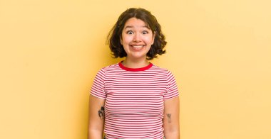 Güzel İspanyol bir kadın mutlu ve şapşal görünüyor. Geniş, eğlenceli, kaçık bir gülüşü ve açık gözleri var.