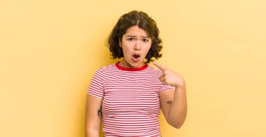 Kızgın, çılgın bir patrona benzeyen sinirli bir ifadeyle kameraya bakan güzel İspanyol bir kadın.