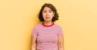 Güzel İspanyol bir kadın üzgün ve mızmızlanıyor. Mutsuz bir bakışla, olumsuz ve hayal kırıklığına uğramış bir tavırla ağlıyor.