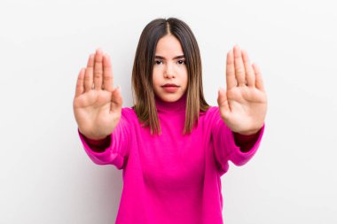 Güzel İspanyol bir kadın ciddi, mutsuz, kızgın ve hoşnutsuz görünüyor. Girmeyi yasaklıyor ya da her iki avuçta da dur diyor.