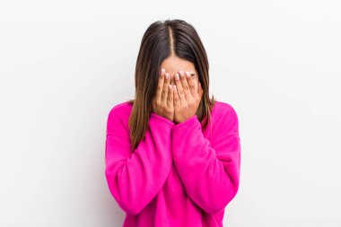 Güzel İspanyol bir kadın üzgün, hayal kırıklığına uğramış, gergin ve depresif, iki eliyle yüzünü kaplayan, ağlayan