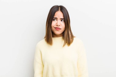 Güzel İspanyol bir kadın kafası karışmış ve şaşkın görünüyor, merak ediyor ya da bir sorunu çözmeye çalışıyor veya düşünüyor.