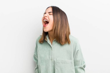 Güzel İspanyol kadın öfkeyle bağırıyor, agresif bir şekilde bağırıyor, stresli ve kızgın görünüyor.