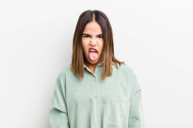 Güzel İspanyol bir kadın tiksinmiş ve rahatsız olmuş hissediyor, dilini dışarı çıkarıyor, iğrenç ve tiksindirici şeylerden hoşlanmıyor.