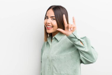 Oldukça İspanyol bir kadın mutlu, eğlenceli, kendinden emin, pozitif ve asi hissediyor, elle rock veya heavy metal işareti yapıyor.