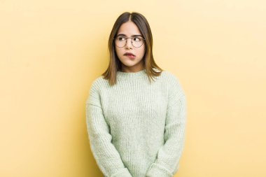 Güzel İspanyol bir kadın şüpheleniyor ya da düşünüyor, dudağını ısırıyor ve kendine güveni yok ve gergin hissediyor, kenarda yer arıyor.