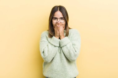 Güzel İspanyol kadın mutlu, neşeli, şanslı ve şaşkın görünüyor. İki eliyle ağzını kapatıyor.