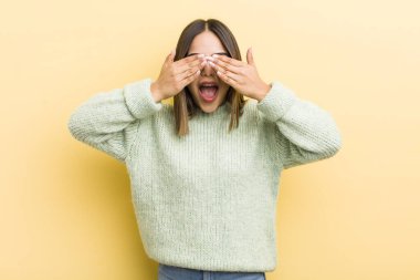 Güzel İspanyol kadın gülümsüyor ve mutlu hissediyor, iki eliyle gözlerini kapatıyor ve inanılmaz bir sürpriz bekliyor.