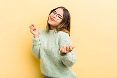 Güzel İspanyol kadın gülümsüyor, kaygısız hissediyor, rahat ve mutlu, dans ediyor ve müzik dinliyor, bir partide eğleniyor.