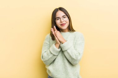 Güzel İspanyol bir kadın mutlu ve başarılı hissediyor, gülümsüyor ve alkışlıyor, alkışlarla tebrik ediyor.