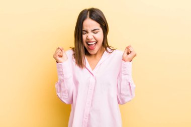 Güzel İspanyol kadın çok mutlu ve şaşırmış görünüyor, başarıyı kutluyor, bağırıyor ve zıplıyor.