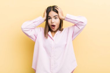 Güzel İspanyol bir kadın heyecanlı ve şaşırmış görünüyor, ağzı açık, iki eli başında, şanslı bir kazanan gibi hissediyor.