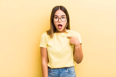 Şok olmuş ve ağzı açık, kendini işaret eden güzel İspanyol bir kadın.