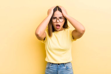 Güzel İspanyol bir kadın stresli ve endişeli, depresif ve hayal kırıklığına uğramış hissediyor, iki elini de başa kaldırıyor.