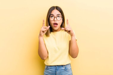 Güzel İspanyol bir kadın şaşkınlık içinde ve ağzı açık. Şok olmuş ve şaşırmış bir bakışla yukarı bakıyor.