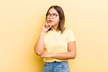 Güzel İspanyol bir kadın, yoğun bakışlı, şüpheli bir ifadeyle merak ediyor, yukarı ve yana bakıyor