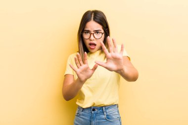 Tatlı İspanyol kadın korkmuş, geri çekiliyor ve korku ve panik içinde bağırıyor, bir kabusa tepki veriyor.